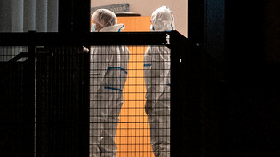 Mitarbeiter der Spurensicherung stehen in einem Gebäude der Zeugen Jehovas. Foto: Daniel Bockwoldt/dpa/Daniel Bockwoldt
