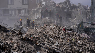 Rettungskräfte suchen in den Trümmern nach Überlebenden. Foto: Hussein Malla/AP/dpa