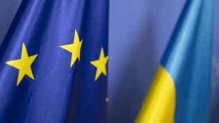 ARCHIV - Die Fahne der Ukraine steht vor der Flagge der europäischen Union. Die EU-Staaten wollen der Ukraine in den kommenden zwölf Monaten eine Million neue Artilleriegeschosse für den Kampf gegen Russland liefern. Foto: Christoph Reichwein/dpa