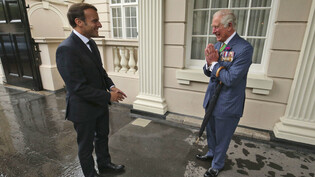 ARCHIV - Der damalige britische Prinz Charles (r.) begrüßt im Juni 2020 Frankreichs Präsidenten Emmanuel Macron im Clarence House in London. Foto: Jonathan Brady/PA/AP