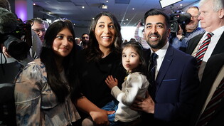 Humza Yousaf (2.v.r) mit seiner Frau Nadia El-Nakla (M) und Familie im Murrayfield-Stadion, nachdem bekannt gegeben wurde, dass er der neue Vorsitzende der Scottish National Party (SNP) ist und der nächste Erste Minister von Schottland werden wird. Foto:…