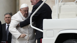 Papst Franziskus wird am Ende der wöchentlichen Generalaudienz auf dem Petersplatz in sein Auto geholfen. Foto: Alessandra Tarantino/AP/dpa