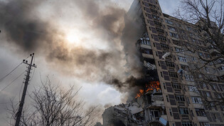 Ein Gebäude mit mehreren Geschäften brennt in Awdijiwka nach einem Luftangriff. Foto: Evgeniy Maloletka/AP