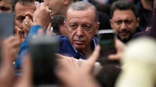 Recep Tayyip Erdogan (M) verlässt nach der Stimmabgabe ein Wahllokal in Istanbul. Foto: Emrah Gurel/AP/dpa