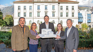 So soll es dereinst aussehen: Die Grossratsmitglieder Mario Salis, Laura Oesch, Gian Derungs, Julia Müller und Felix Schutz (von links) präsentieren vor dem alten Staatsgebäude das Modell für den Erweiterungsbau. 