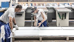Sie bekommen bald T-Shirts mit neuem Aufdruck: Zwei Mitarbeiter stellen in der Niederurner Eternit-Fabrik Faserzementplatten her. 
