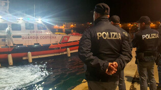 Am frühen Freitagmorgen auf Lampedusa: Polizisten erwarten die Ankunft der Küstenwache mit 42 lebenden und acht toten Migranten.