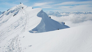 Über den Wolken: Skitourengeher steigen eine Wechte entlang auf das Monsteiner Büelenhorn.