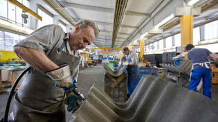 Nach 66 Jahren ist Schluss: Die Swisspearl stellt die Produktion an ihrem Werk in Payerne ein. Dort stellten die Mitarbeitenden unter anderem gewellte Eternitplatten-Giebelstücke her. 