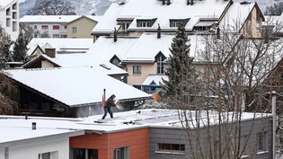 Schnee macht Arbeit: Der Fotograf entdeckt seinen Nachbarn, wie er Schnee vom Dach schaufelt.