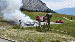 Brandursache noch unbekannt: Einsatzkräfte der Feuerwehr löschen in Flims ein brennendes Fahrzeug. 