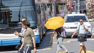 Die Menschen haben sich während der Hitzewelle mit Schirmen vor der Sonne und Hitze zu schützen versucht.