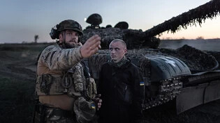 Ein kommandierender Soldat der 22. Brigade der Ukraine gibt bei einer Nachtschießübung vor einem T-72 Panzer Anweisungen. Foto: Oliver Weiken/dpa