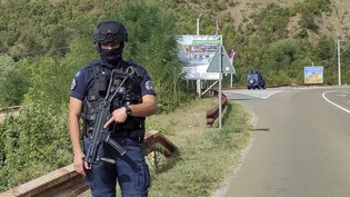 Nach dem Angriff bewachr ein kosovarischer Polizist eine Straße in der Nähe von Banjska, 55 Kilometer nördlich der Hauptstadt Pristina im Norden des Kosovo. Foto: Dejan Simicevic/AP/dpa