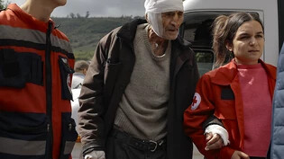 Ein verwundeter armenischer Mann wird von Freiwilligen bei seiner Ankunft in der armenischen Stadt Goris in der Region Syunik, Armenien gestützt. Foto: Vasily Krestyaninov/AP/dpa