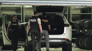 Polizisten in Schutzwesten untersuchen das Auto des erschossenen Staatsanwalts César Suárez in Guayaquil, Ecuador. Während sich kriminelle Banden und staatliche Sicherheitskräfte in Ecuador heftige Kämpfe liefern, ist ein für die Ermittlungen gegen die…