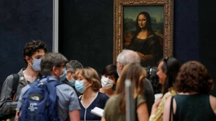 ARCHIV - Journalisten stehen vor der Mona Lisa. Foto: Christophe Ena/AP/dpa