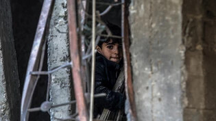 dpatopbilder - Ein palästinensisches Kind inspiziert beschädigte Gebäude nach israelischen Luftangriffen in Rafah. Foto: Abed Rahim Khatib/dpa