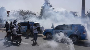 ARCHIV - Senegalesische Bereitschaftspolizisten werfen Tränengas auf Anhänger der Opposition. Nach der Verschiebung der ursprünglich im Februar geplanten Präsidentenwahl protestierte die Opposition. Foto: Stefan Kleinowitz/AP/dpa