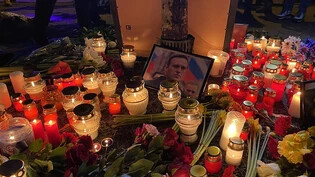 Ein Bild mit dem Portrait von Alexey Nawalny und Kerzen stehen auf dem Platz gegenüber der russischen Botschaft in Riga (Lettland). Foto: Alexander Welscher/dpa