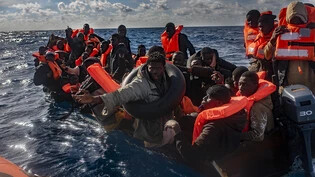ARCHIV - Mehrere Migranten in einem Boot im Mittelmeer, während Rettungskräfte versuchen ihnen zu helfen. Foto: Antonio Sempere/EUROPA PRESS/dpa