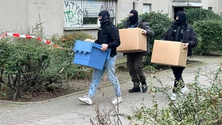 Ermittler gehen mit Kisten und Kartons in das Wohnhaus der früheren RAF-Terroristin Daniela Klette. Foto: Paul Zinken/dpa