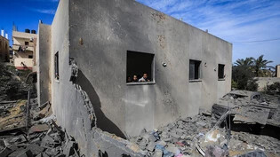 Palästinenser schauen aus einem Fenster, nachdem ein israelischer Luftangriff das Haus der Familie Al-Shaer östlich von Rafah zerstört hat. Foto: Mohammed Talatene/dpa