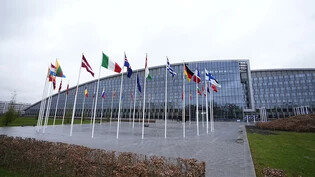 Die Flaggen der NATO-Mitgliedsstaaten flattern im Wind vor dem NATO-Hauptquartier. Die Nato-Außenminister kommen in Brüssel zusammen, um über Pläne für eine besser vorhersehbare, längerfristige Unterstützung der Ukraine zu beraten. Foto: Virginia Mayo/AP…