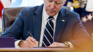 ARCHIV - Joe Biden, Präsident der USA, unterschreibt ein Dokument. Foto: Andrew Harnik/AP/dpa