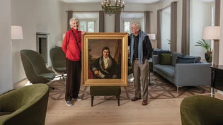 Präsenter Gründer: Das Eigentümerpaar des «Parkhotels Margna» in Sils, Isot und Christoph Sautter, halten das Porträt von Johann Josty in Ehren.