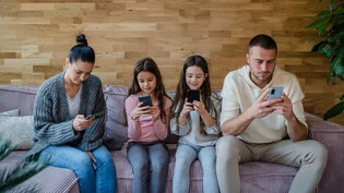 Jeder für sich selbst in der eigenen Welt: eine Familie und ihre Smartphones. 
