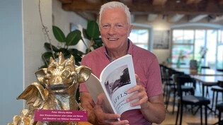 Im «Kafi Beuge» in Näfels: Peter Märchy-Müller präsentiert stolz seinen goldenen Drachen. Ein Preis, den er für seine Bücher erhalten hat. 