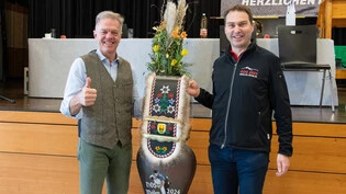 Traditionelle Geste: Rolf Figi (rechts) übergibt als OK-Präsident des NOS 2023 in Mollis seinem Nachfolger Ueli Schlumpf vom OK Meilen eine Treichel für den Gabentempel.