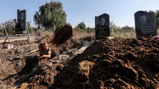 Herbst letzten Jahres: Ein Arbeiter hebt das Grab eines Mannes aus, der während der russischen Besetzung des ukrainischen Dorfes Sawynzi in der Region Charkiw gefoltert und getötet wurde.  