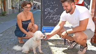 Hundehalterin Luana Miglio und Kioskbetreiber Artjan Sadiki freuen sich über Oskars Appetit auf Hunde-Glacé. 