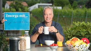 Lebt direkt neben einem Rebberg: Walter Fromm, kantonaler Rebbaukommissär, beim Frühstück auf der Veranda seines Wohnhauses in Maienfeld. 