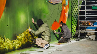 Die Unterführung wird farbig: Die beiden Streetart-Künstler Bane und Cheone sprayen bei der Talstation Rothorn.