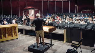 Oper im Zelt: Dirigent Gion Gieri Tuor (Mitte) leitet die Probe der Opera Viva in Obersaxen; Pianist Mateusz Niedzwiedzki (links) begleitet Chor und Solisten am Klavier, bis die Orchesterproben beginnen..