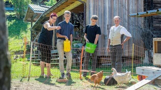 Zusammenarbeit durch Agriviva: Doris Flütsch, Valters Alberts Palejs, Christian Quagelli und Peter Flütsch (von links) füttern gemeinsam die Hühner.
