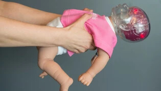 Lebensgefährlich: Was ein Schütteln bei einem Baby in den Hirnregionen bewirkt, zeigen die roten Lämpchen im Kopf der Simulationspuppe.